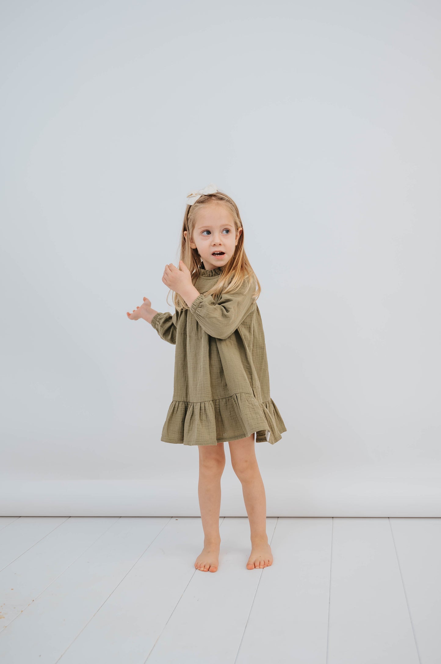 SOALSA muslin dress worn by child modeled as Božične obleke za otroke in neutral background
