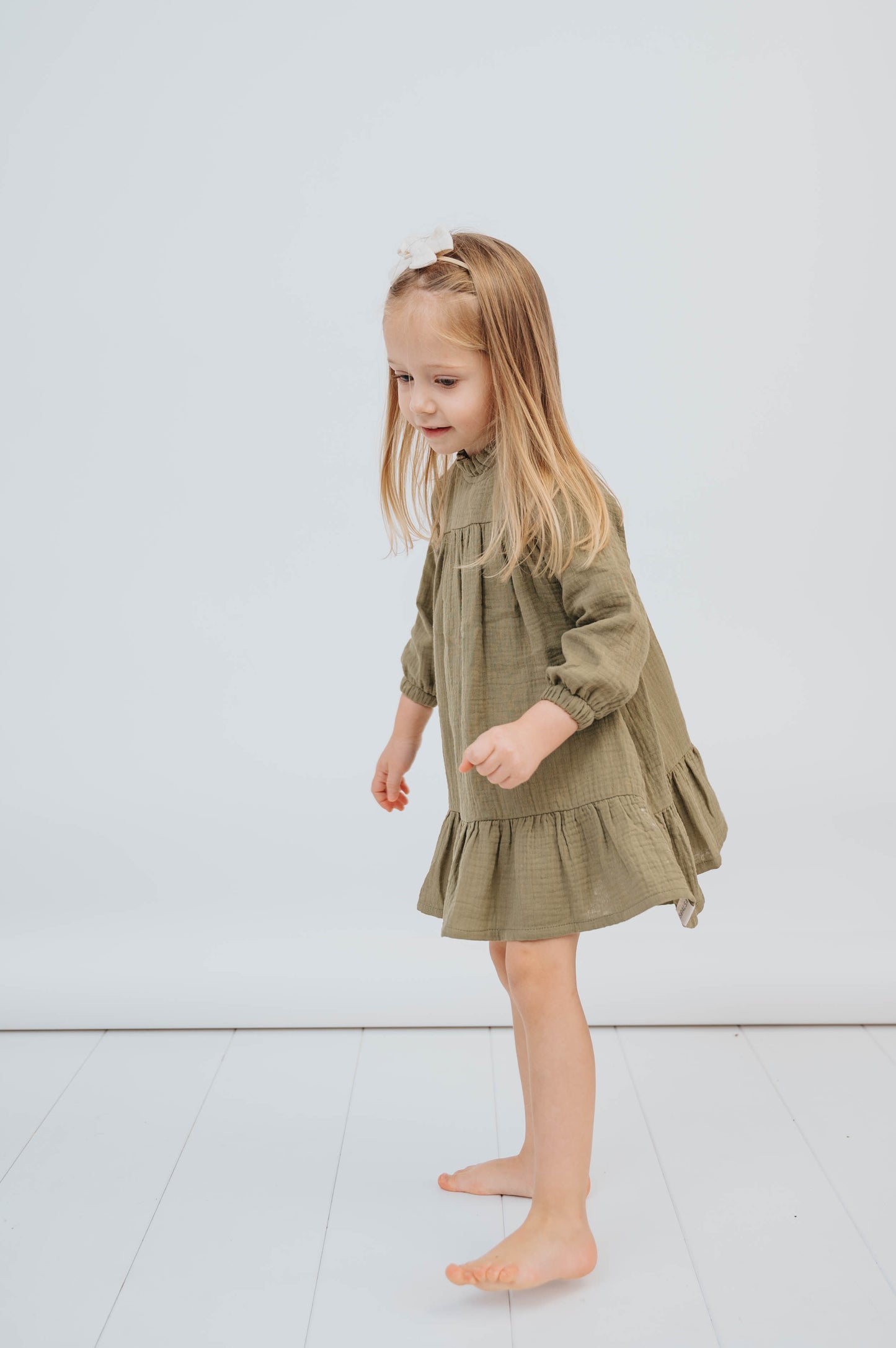 SOALSA muslin dress worn by young girl with long blonde hair standing barefoot Božične obleke za otroke