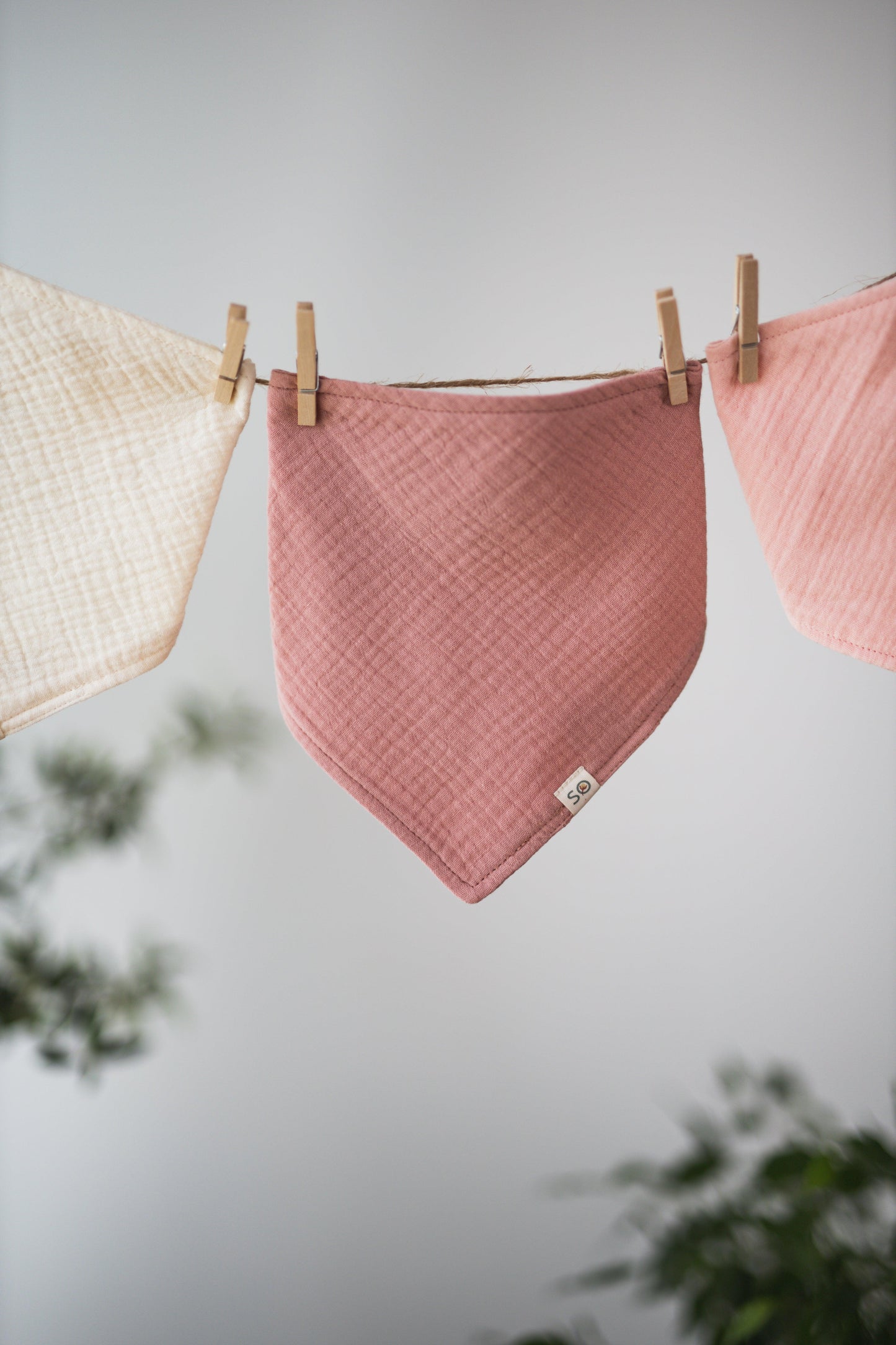 SOALSA baby bibs in soft pastel colors hanging on a clothesline rutice za dojenčke