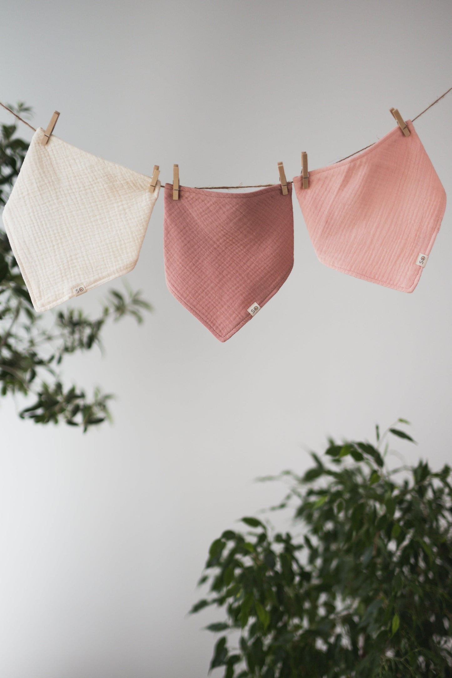 SOALSA baby bibs hanging on a clothesline in white, dusty rose, and light pink colors rutice za dojenčke