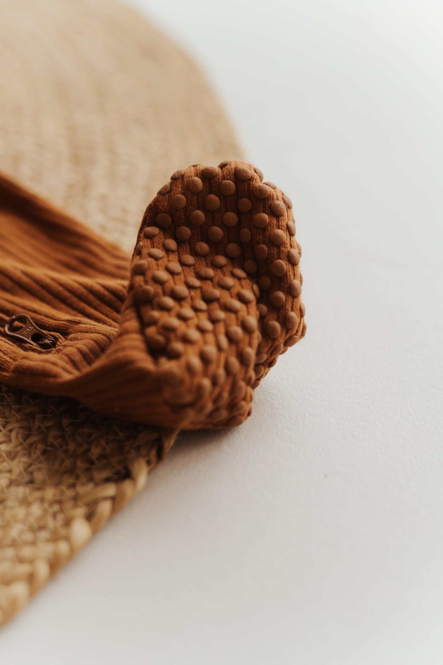 Close-up of brown SOALSA baby sleep romper foot with textured sole Spalni Pajaci za Dojenčke