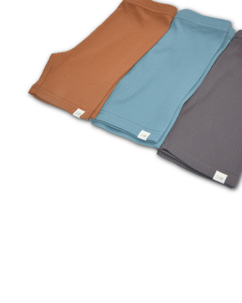 Three folded fabrics in brown, blue, and gray on a white background