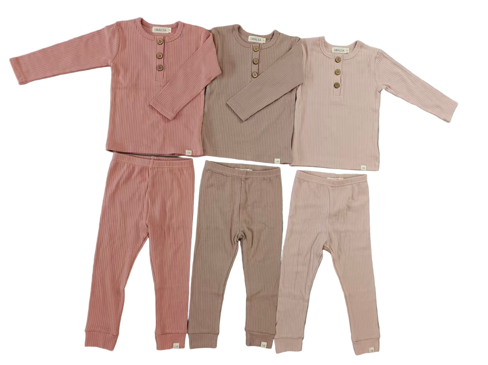 Children's clothing set with two shirts and two pants on a gray surface