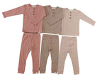 Children's clothing set with two shirts and two pants on a gray surface