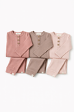 Set of three children's outfits in pink and brown on a white background
