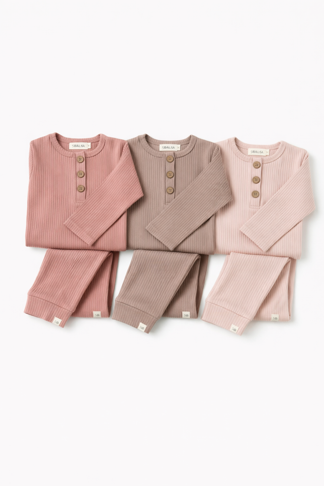 Set of three children's outfits in pink and brown on a white background
