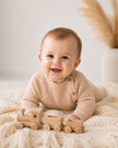 Baby playing with a wooden toy train on a soft surface