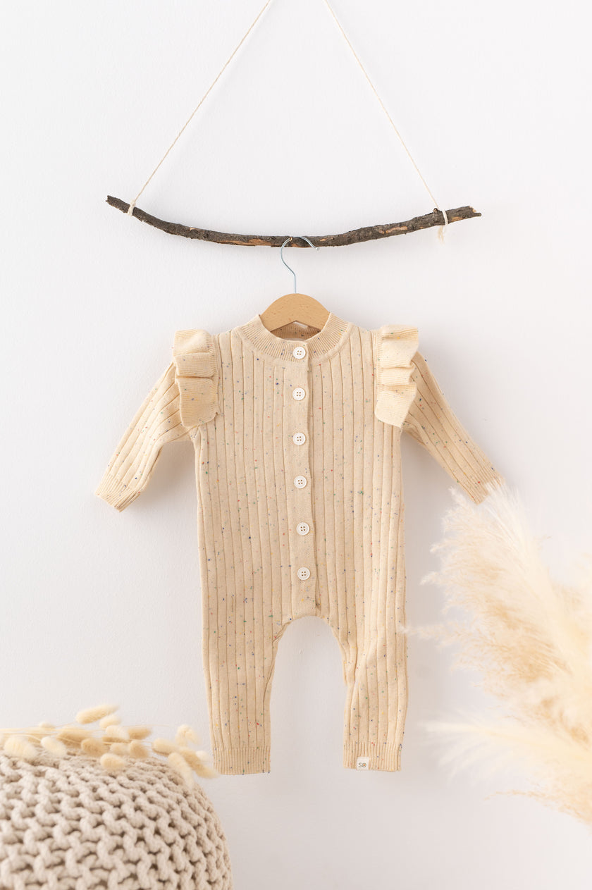 Beige baby romper on a hanger against a white background