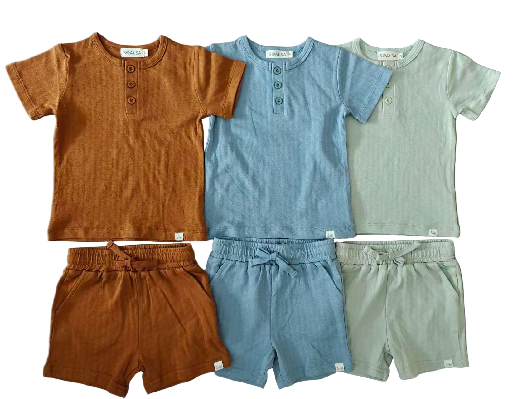 Three children's outfits in brown, blue, and gray on a gray background
