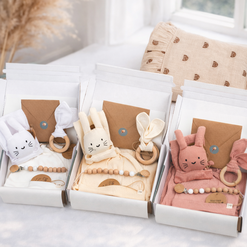 Three baby toys in gift boxes on a light surface with a blurred background