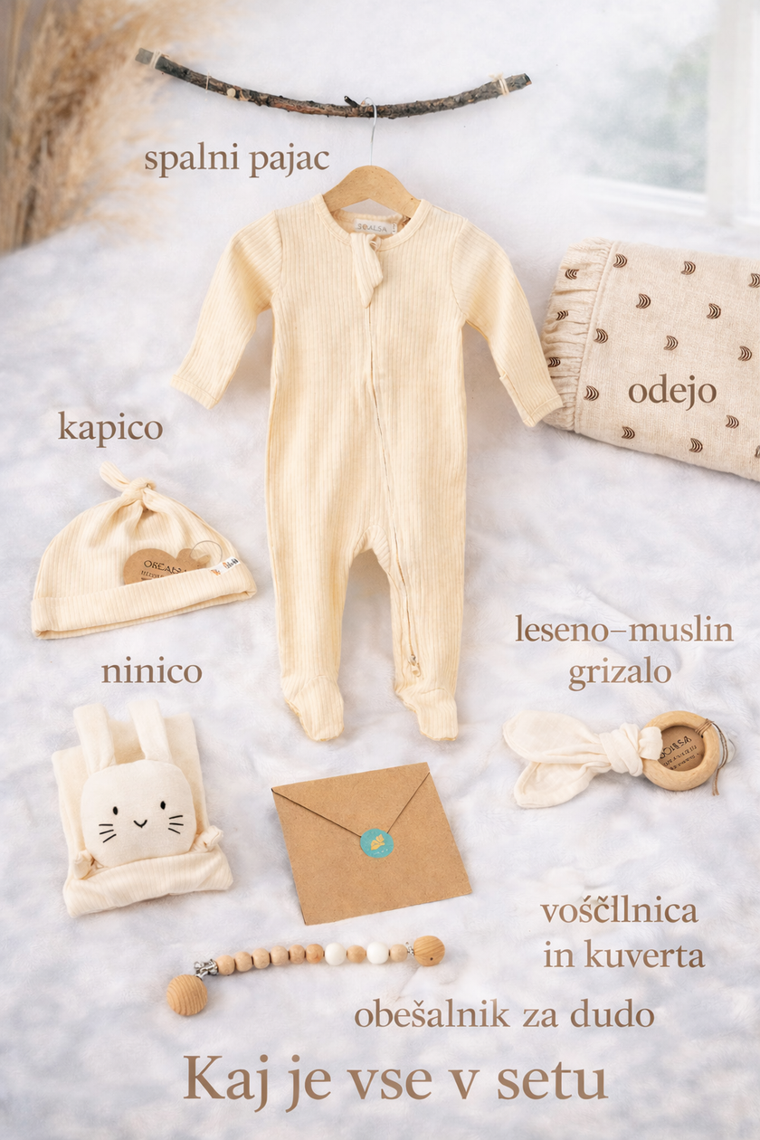 Baby clothing and accessories on a soft surface with text labels in a foreign language.