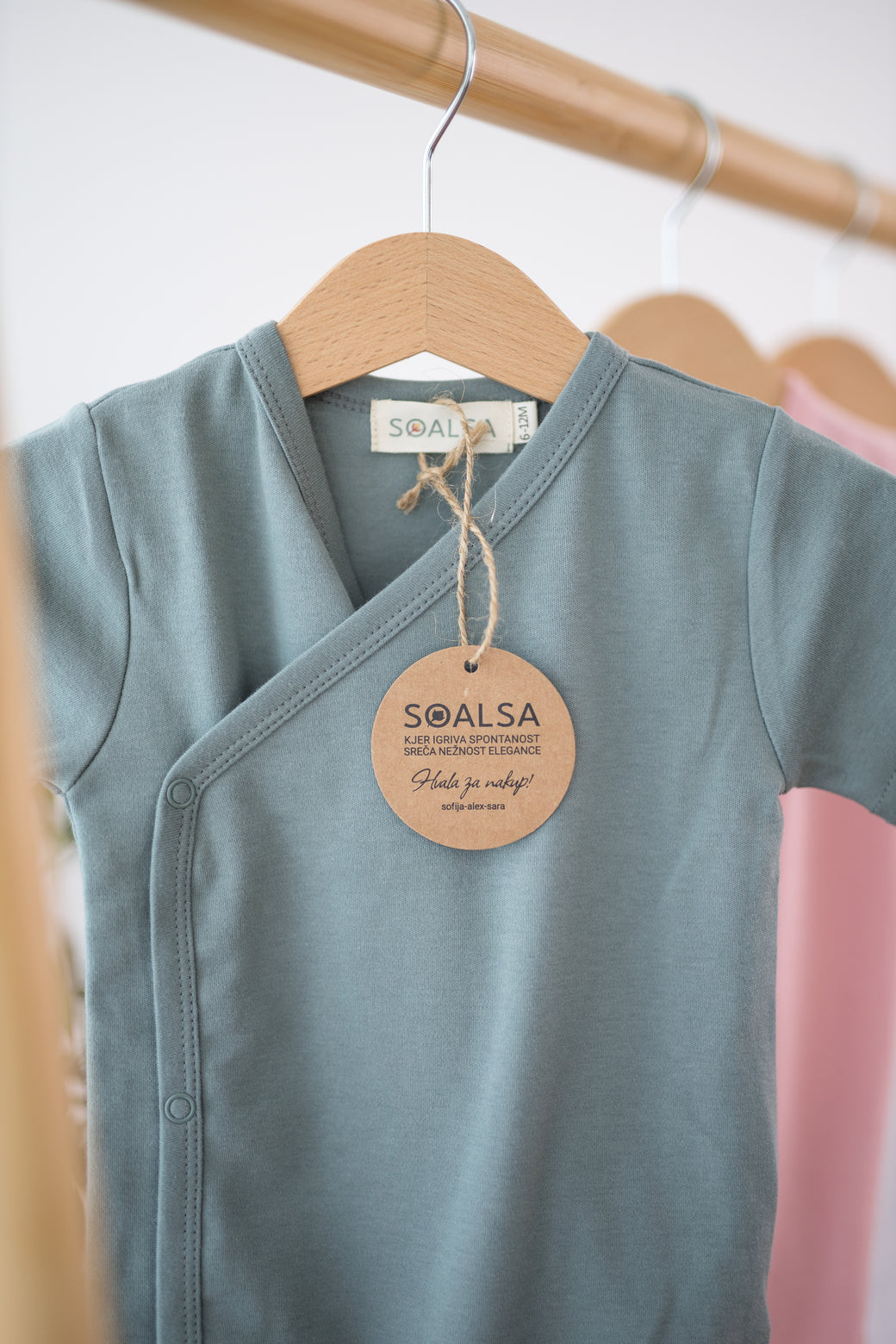 SOALSA kimono side-snap bodysuit in soft green with bodi na preklop style hanging on wooden hanger