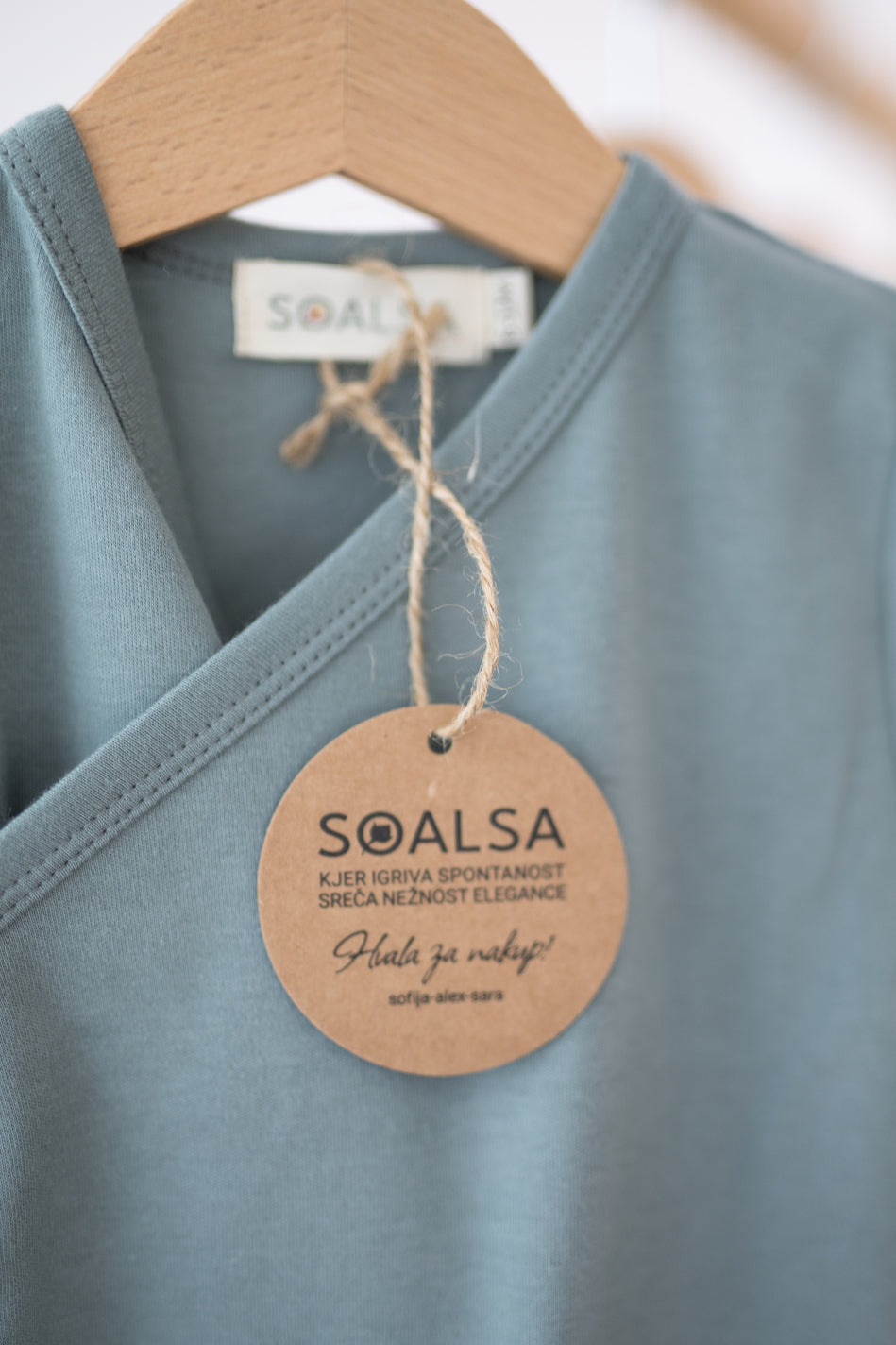 SOALSA kimono side-snap bodysuit in soft blue close-up with bodi na preklop design tag
